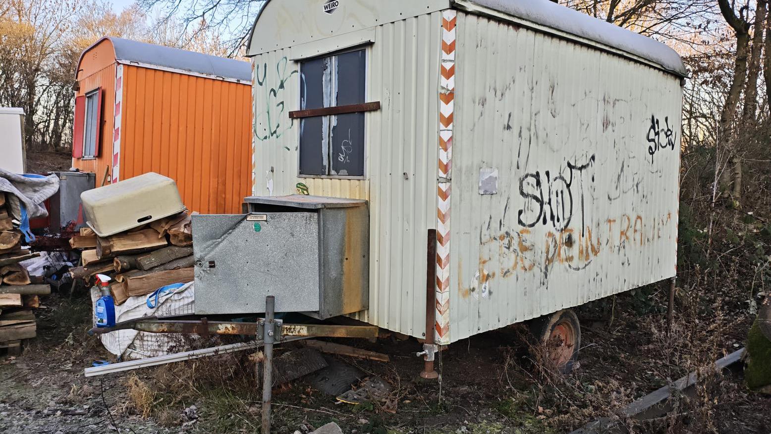 Grauer Bauwagen mit Graffiti