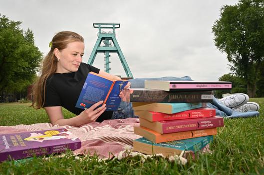 Eine Frau liest ein Buch vor dem Bergbaumuseum