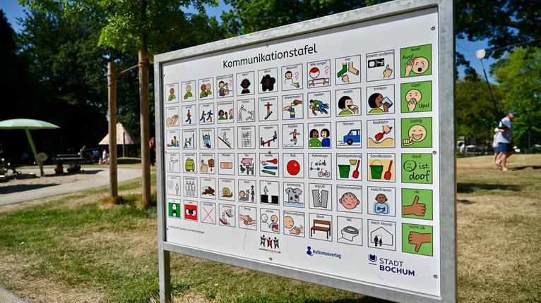 Kommunikationstafel mit Piktogrammen auf einem Spielplatz im Stadtpark.