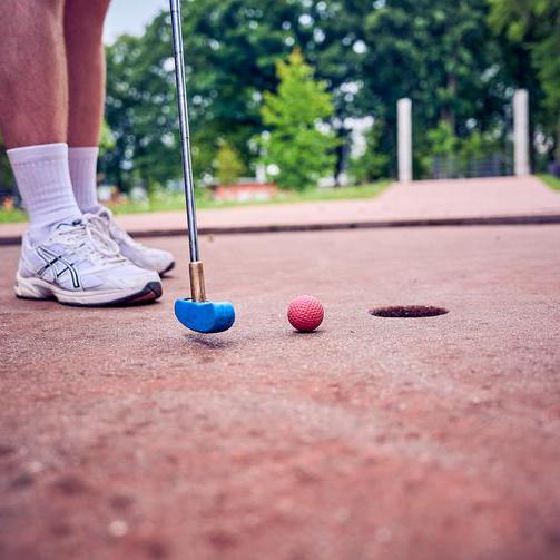 Nahaufnahme von einem Minigolfschläger und einem Ball.