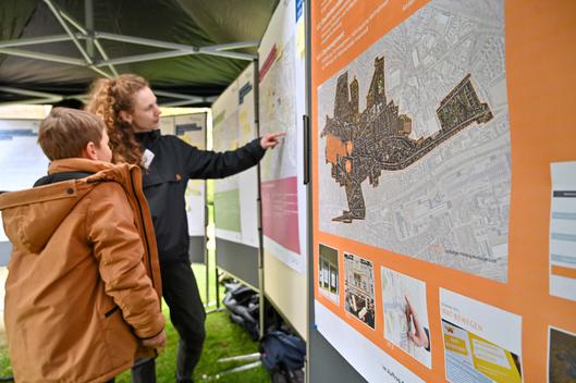 Zwei Personen schauen sich das Stadtentwicklungskonzept an